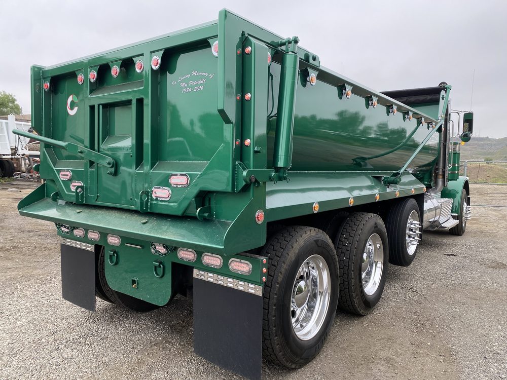 Green dump body, rear three quarter view, tailgate closed