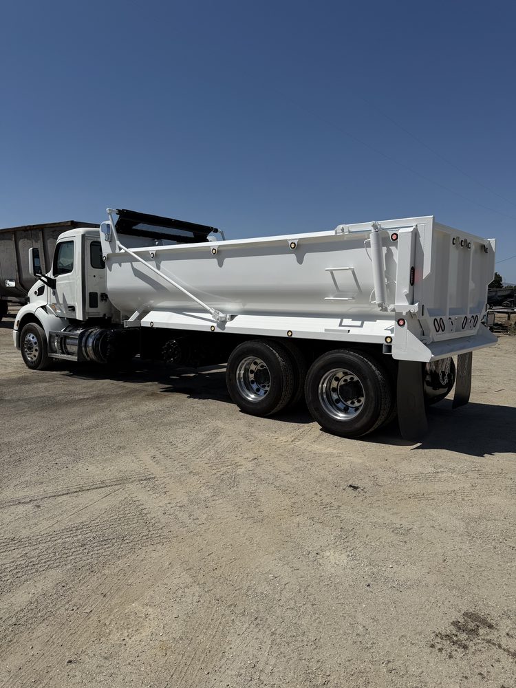 White dump body seen from the side on its chassis