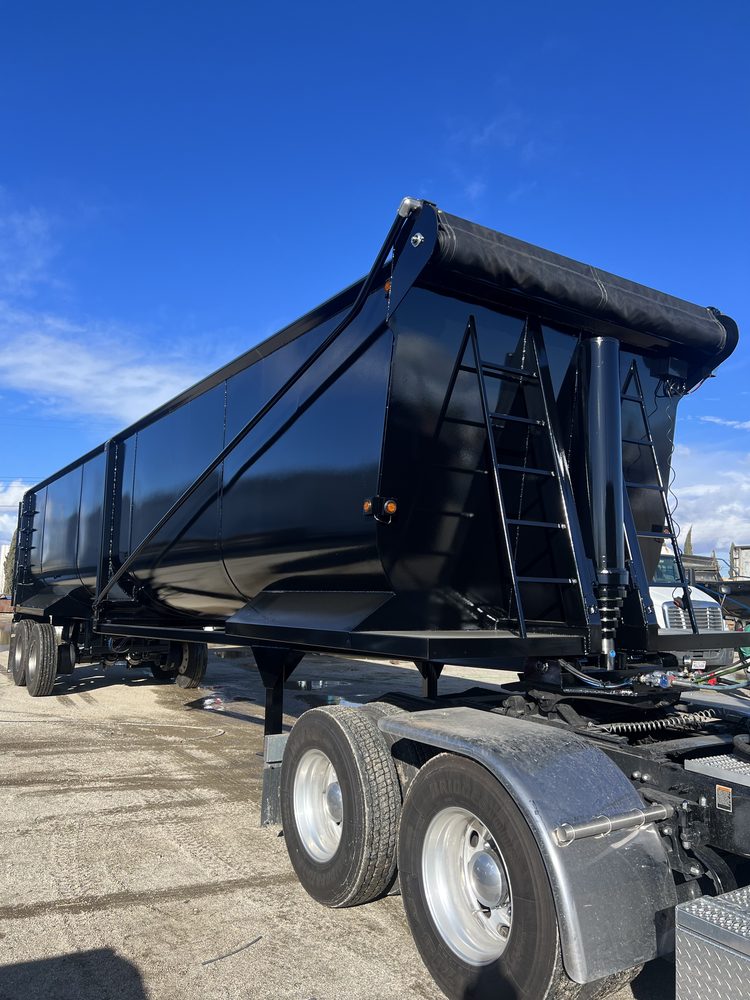 End dump trailer with its tarp rolled and stowed