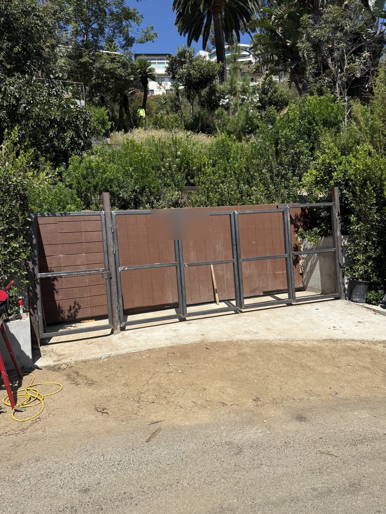 Welded steel gate frames standing next to their infill panels before hanging