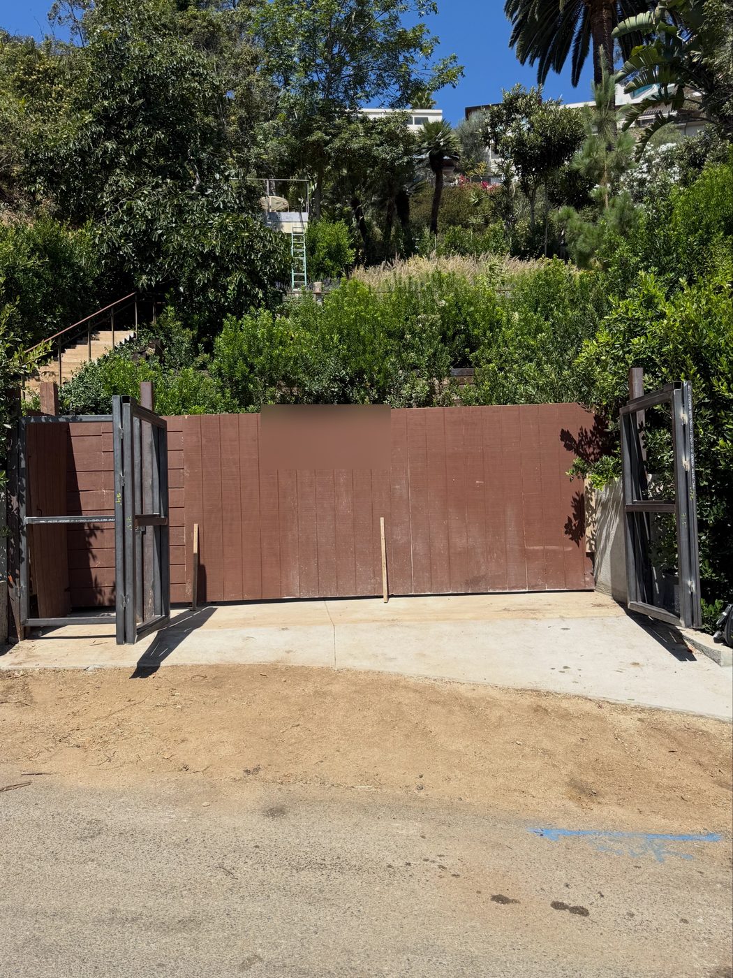 Steel framed driveway gate with a solid infill face, hung and closed
