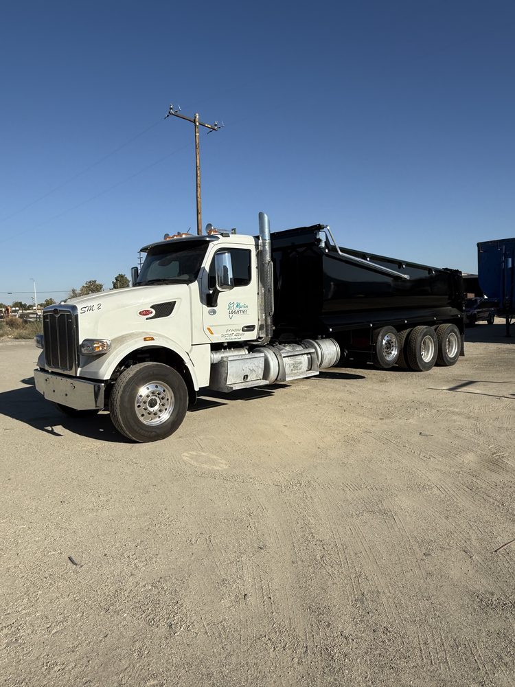White tractor coupled to a black dump body