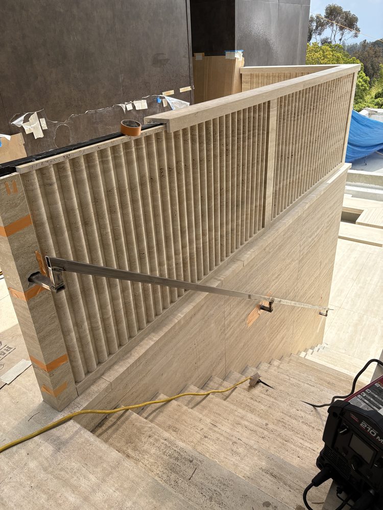 Steel handrail bracketed into a stone stair wall