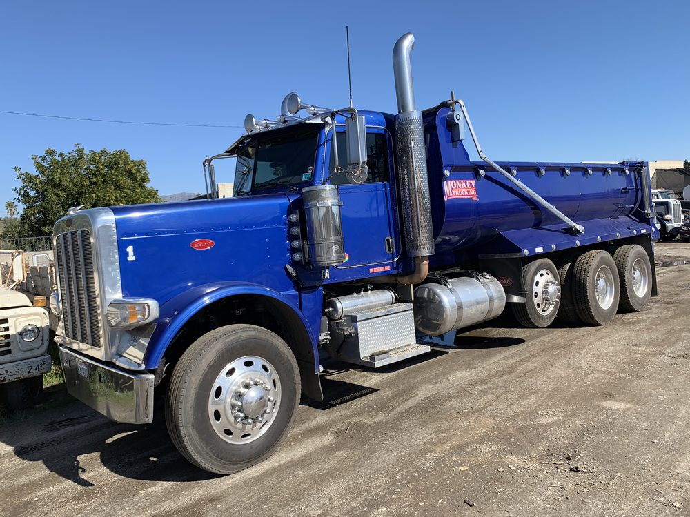 Blue Peterbilt with its dump body, side view